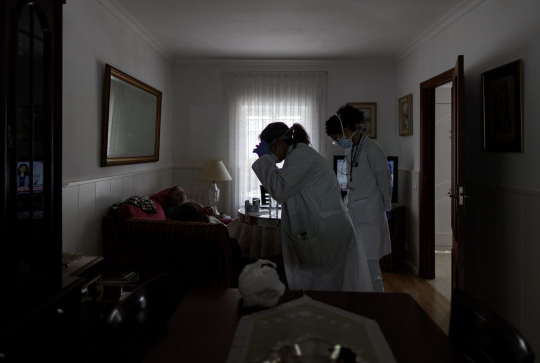 Médicos residentes atienden a domicilio a una anciana durante la pandemia de coronavirus