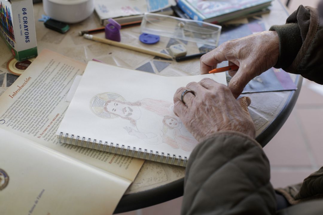 Una anciana realiza un dibujo en el interior de una residencia de mayores.