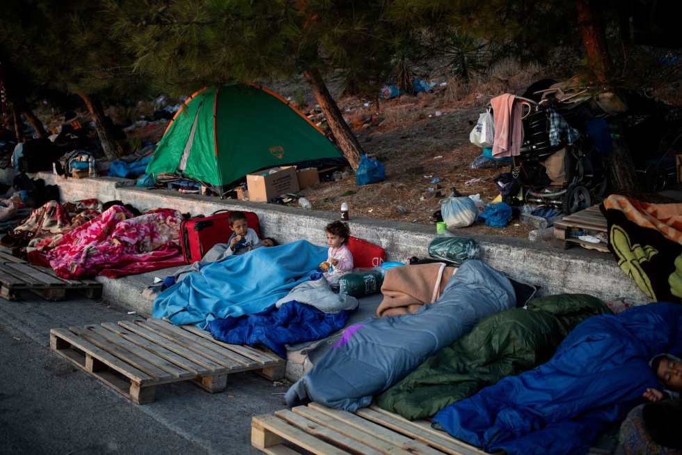 Niños duermen sobre sacos y palés en las cercanías del campamento destrozado de Moria. Niños duermen sobre sacos y palés en las cercanías del campamento destrozado de Moria.