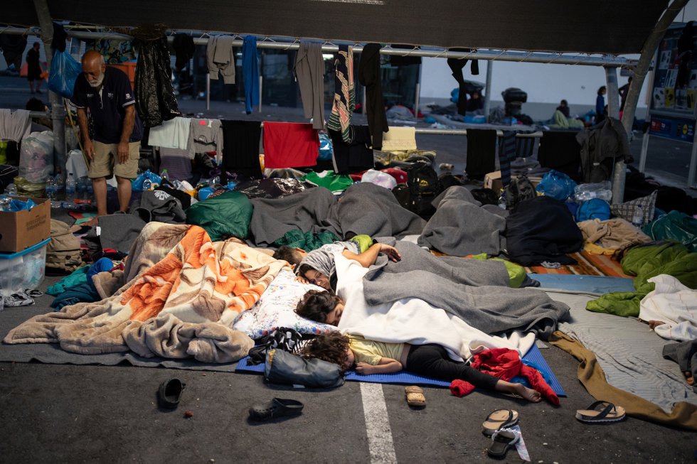 Migrantes y refugiados duermen en el parking cercano a un supermercado de Lesbos. Migrantes y refugiados duermen en el parking cercano a un supermercado de Lesbos.