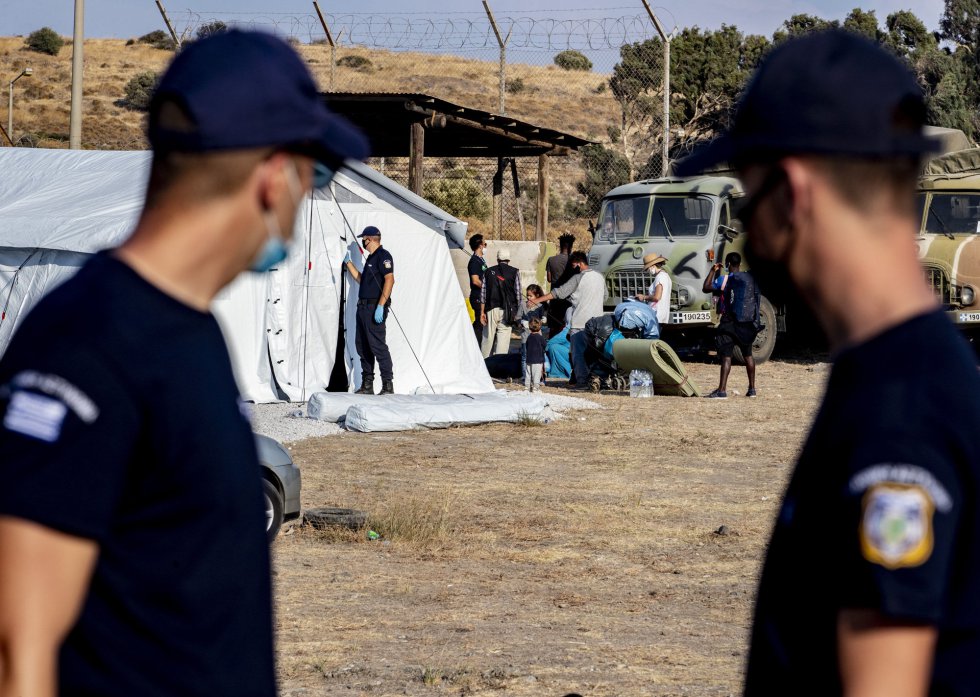 La policía observa el realojo en el campamento temporal de Moria. La policía observa el realojo en el campamento temporal de Moria.