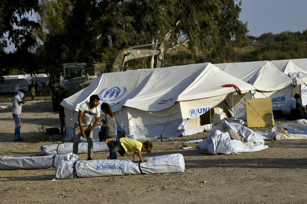 Niños juegan en el campamento temporal habilitado tras la destrucción de Moria. Niños juegan en el campamento temporal habilitado tras la destrucción de Moria.