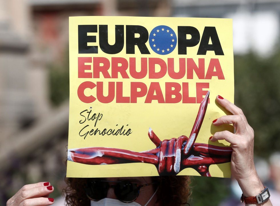Una mujer sostiene un cartel en el que se lee "Europa culpable" durante una manifestación en Pamplona. Una mujer sostiene un cartel en el que se lee "Europa culpable" durante una manifestación en Pamplona.