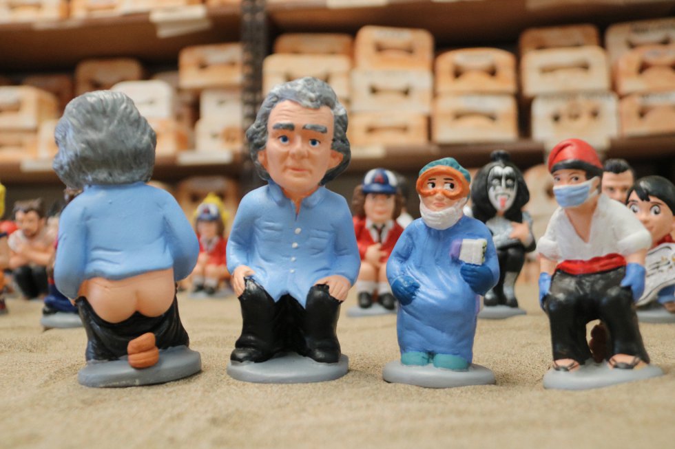 Al 'caganer' clásico, con la típica barretina catalana, este año también le han puesto mascarilla. En la imagen, junto a la figura de Fernando Simón y un sanitario. Al 'caganer' clásico, con la típica barretina catalana, este año también le han puesto mascarilla. En la imagen, junto a la figura de Fernando Simón y un sanitario.