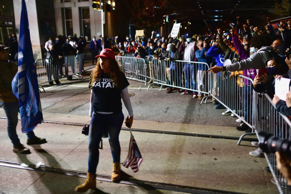 Una partidaria del presidente Donald Trump se burla de los activistas que se congregan detrás de una barrera al otro lado de la calle desde donde se cuentan los votos en Filadelfia
