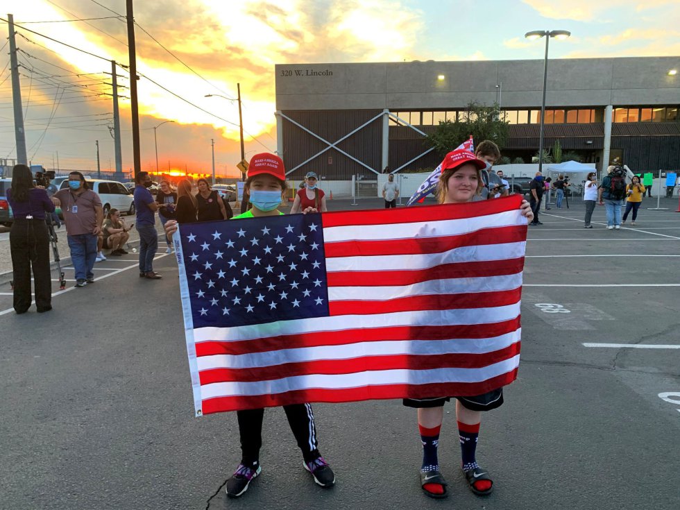 Seguidores del presidente Trump sostienen una bandera estadounidense durante una protesta en Phoenix, Arizona