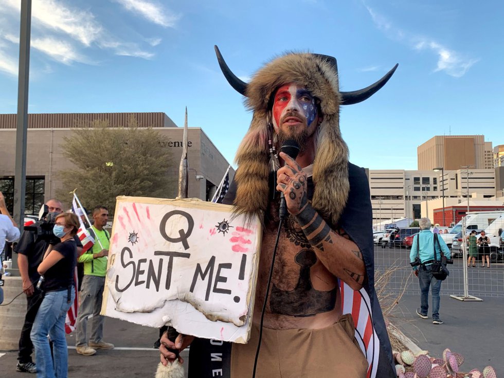 "Yellowstone Wolf" es como se hace llamar este miembro del movimiento QAnon en las redes sociales que habla disfrazado y con una pancarta que dice "Q me envió" en Phoenix