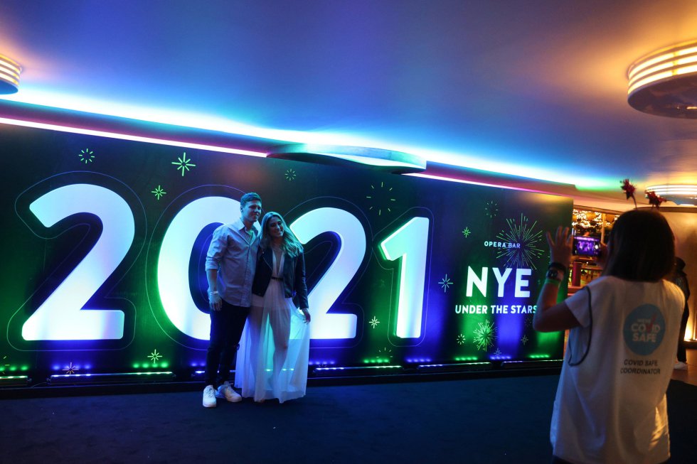Una pareja posa para una foto en la bahía de Sídney en la fiesta de Nochevieja de la ciudad australiana, limitada por las restricciones de la pandemia de COVID-19. Una pareja posa para una foto en la bahía de Sídney en la fiesta de Nochevieja de la ciudad australiana, limitada por las restricciones de la pandemia de COVID-19.
