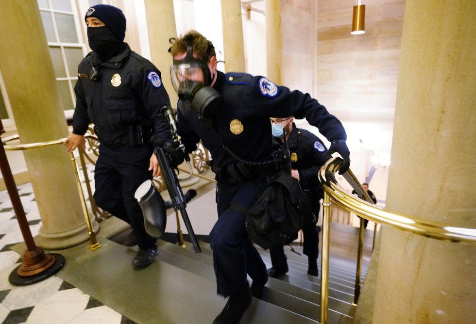 Agentes de la policía toman posición en el interior del Capitolio durante el asalto de los seguidores de Trump. Agentes de la policía toman posición en el interior del Capitolio durante el asalto de los seguidores de Trump.