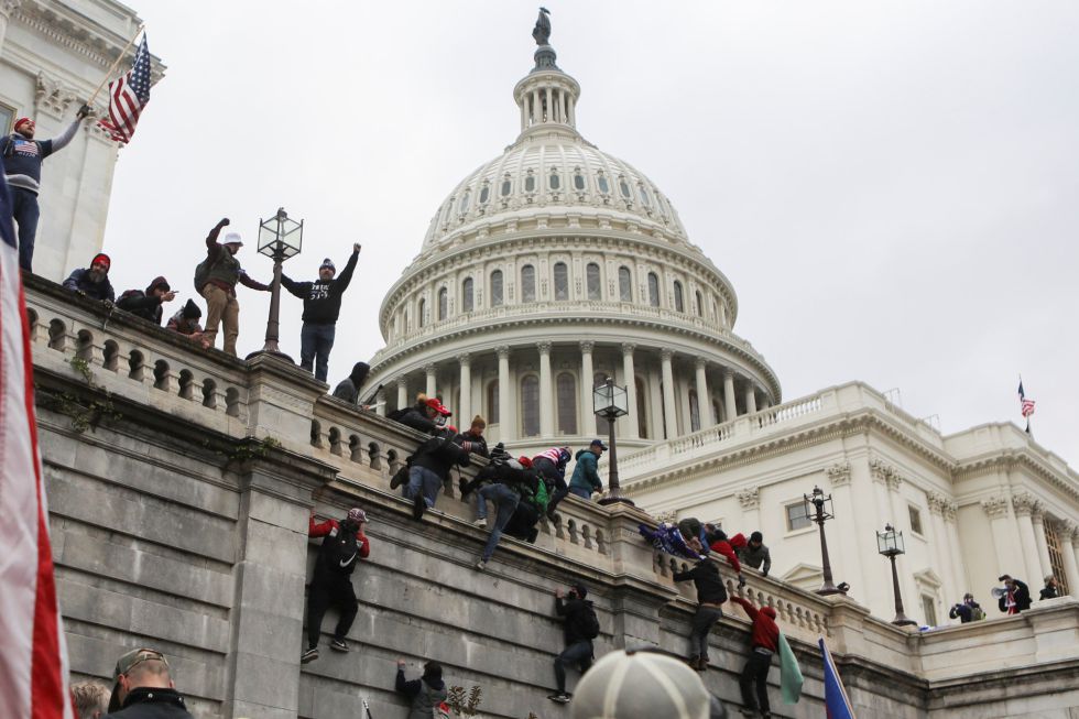 Defensores de Donald Trump trepan por los muros del Capitolio. Defensores de Donald Trump trepan por los muros del Capitolio.