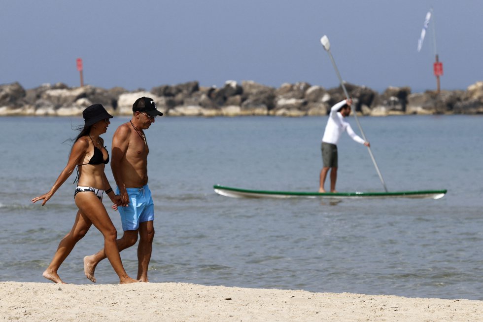 Una pareja pasea sin mascarilla por la playa de la ciudad costera israelí de Tel Aviv. Una pareja pasea sin mascarilla por la playa de la ciudad costera israelí de Tel Aviv.