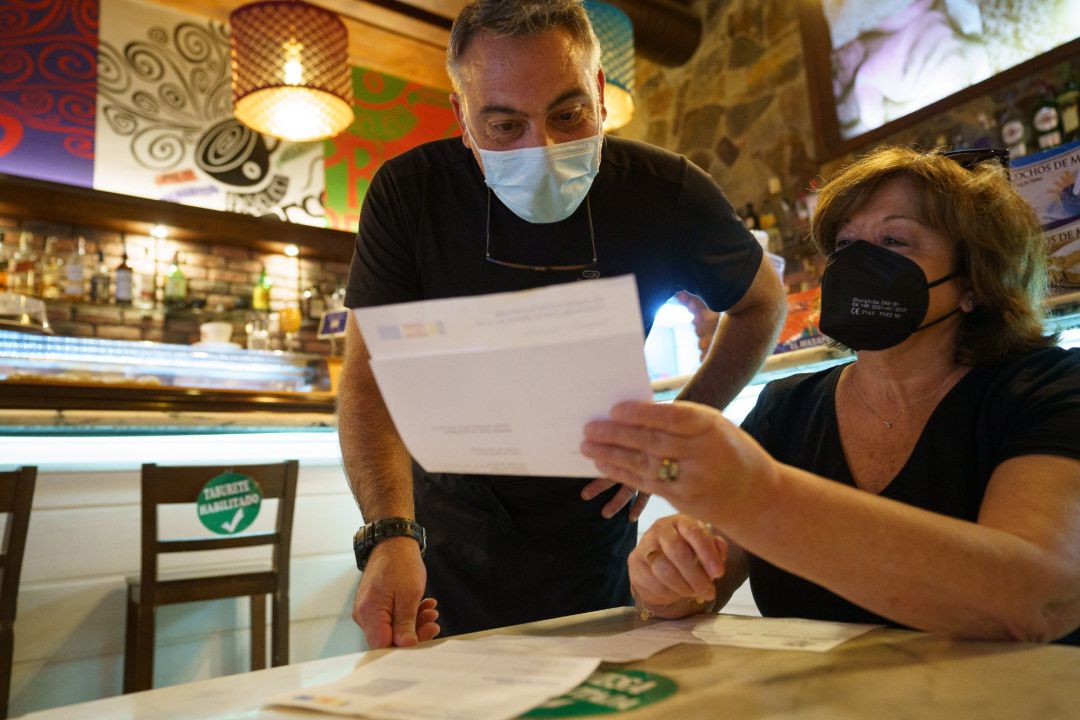 Personal de una cafetería de Santa Cruz de Tenerife, comprueba el certificado Covid de una clienta.
