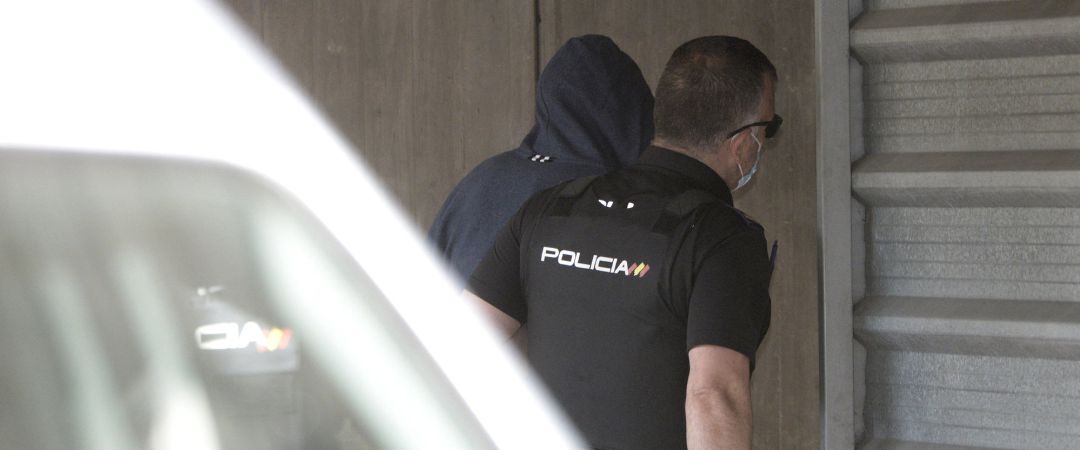 Un agente lleva arrestado a uno de los acusados como presunto autor de la paliza que causó la muerte a Samuel Luiz en A Coruña