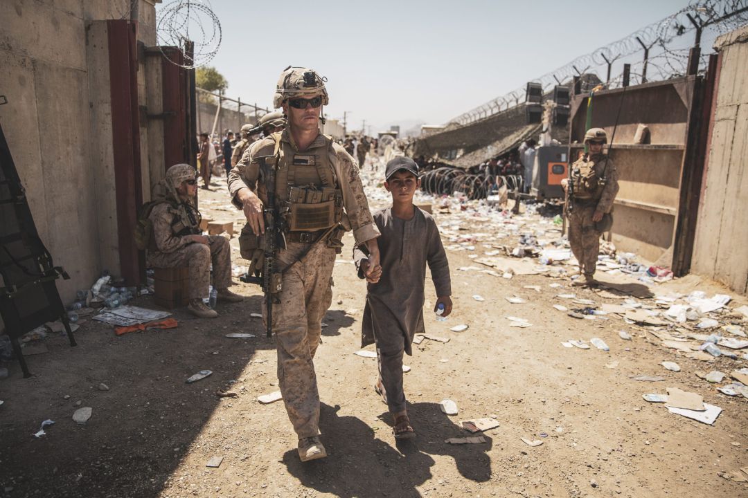Un marine, con un niño afgano, durante las tareas de evacuación. 