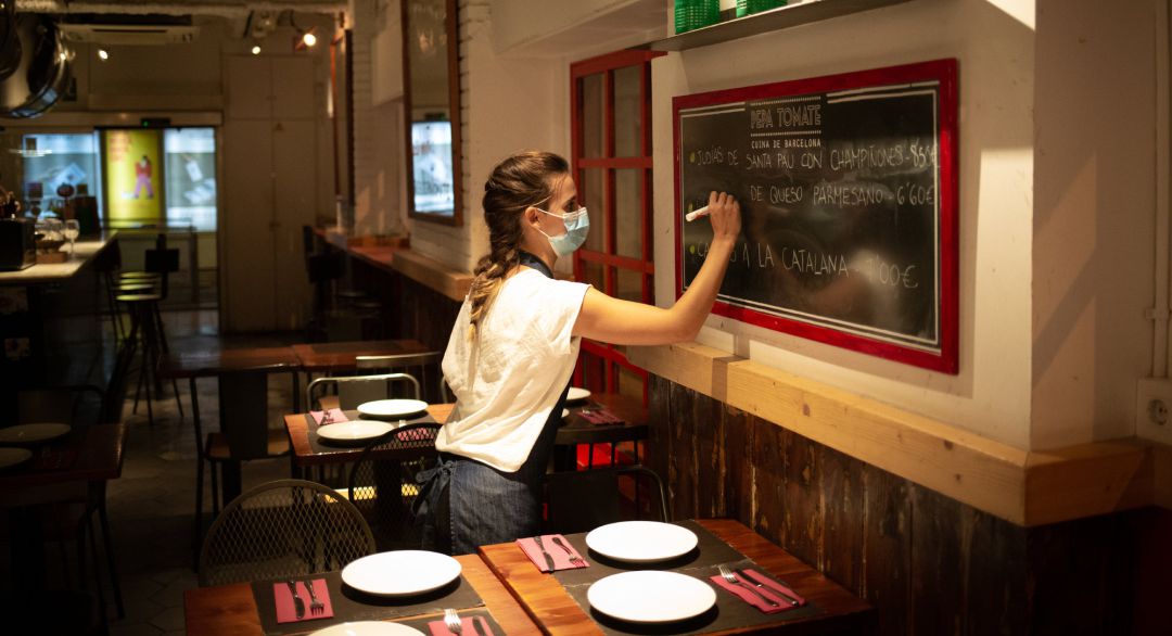 Una camarera apunta platos en una pizarra en el interior de un bar, en una imagen de archivo.