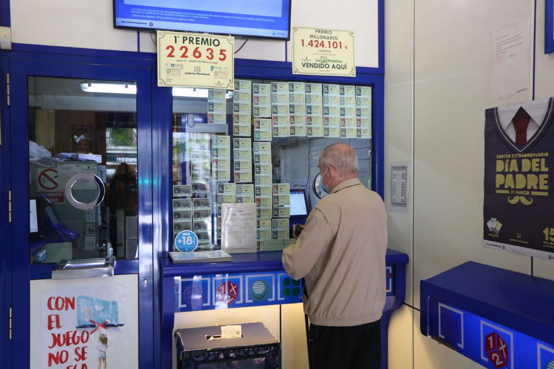 Un hombre compra lotería en una administración