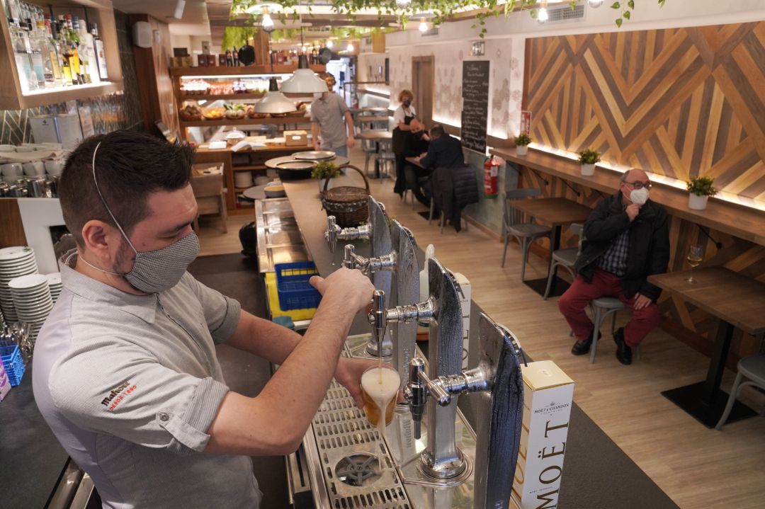 Un camarero llena un vaso de cerveza en un restaurante durante el primer día de la apertura parcial de la hostelería en Santiago de Compostela.