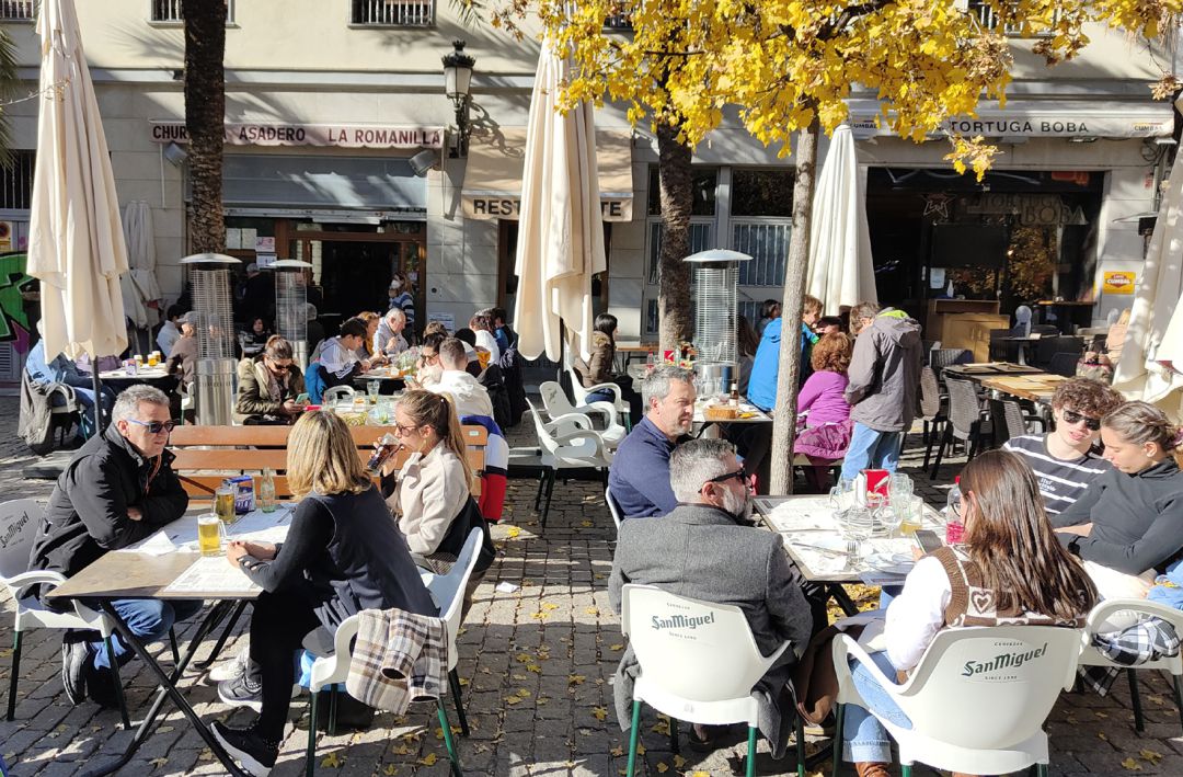 Granadinos y visitantes en una terraza de un bar en la plaza de la Romanilla de Granada este otoño de 2021