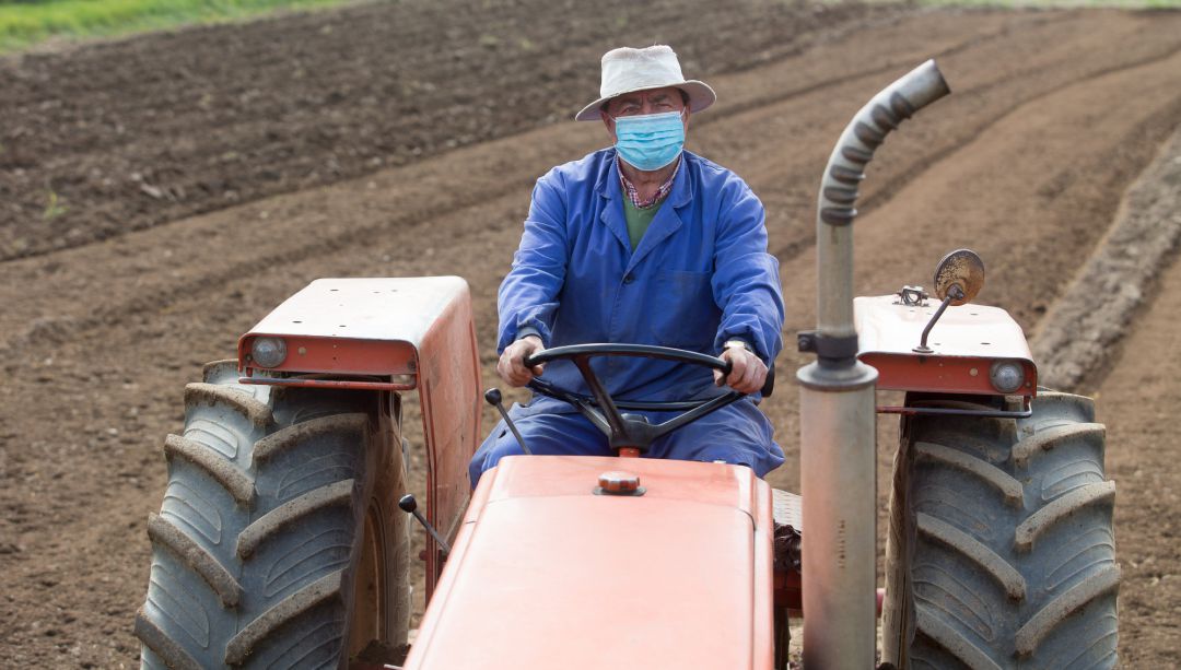 Imagen de archivo de un agricultor con su tractor en el campo