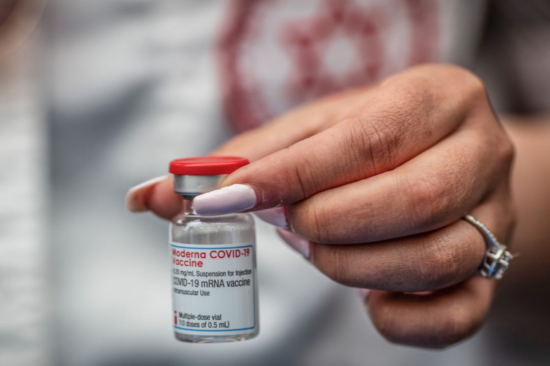 Un sanitario muestra un vial con varias dosis de la vacuna de Moderna