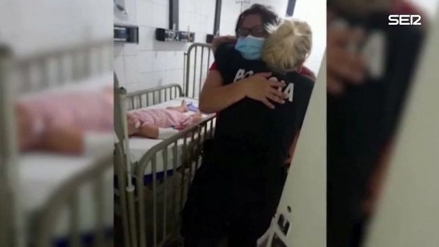 La madre de la niña abraza a la agente que le salvó la vida.