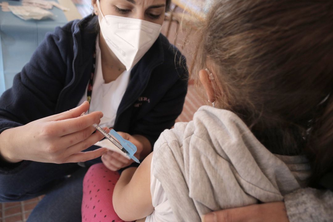 Una niña recibe la vacuna contra el Covid-19, en el CEIP Lucentum, a 13 de enero de 2022, en Alicante, Comunidad Valenciana