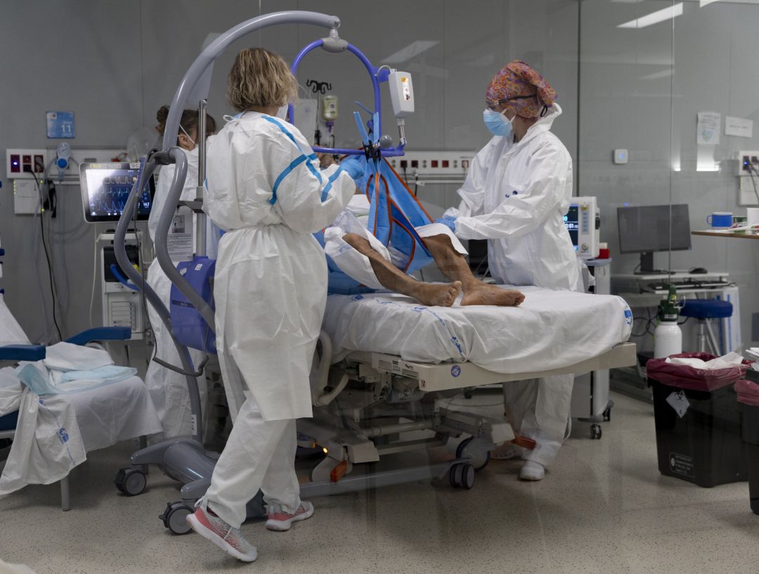 Varios sanitarios alrededor de un paciente ingresado en la UCI del Hospital Enfermera Isabel Zendal, a 13 de enero de 2022, en Madrid (España). 